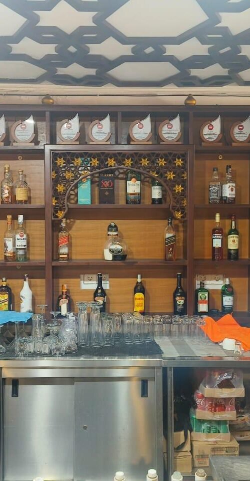 Fully stocked bar counter with top liquor brands and glassware at Bollywood Masalaz Kuta in Bali